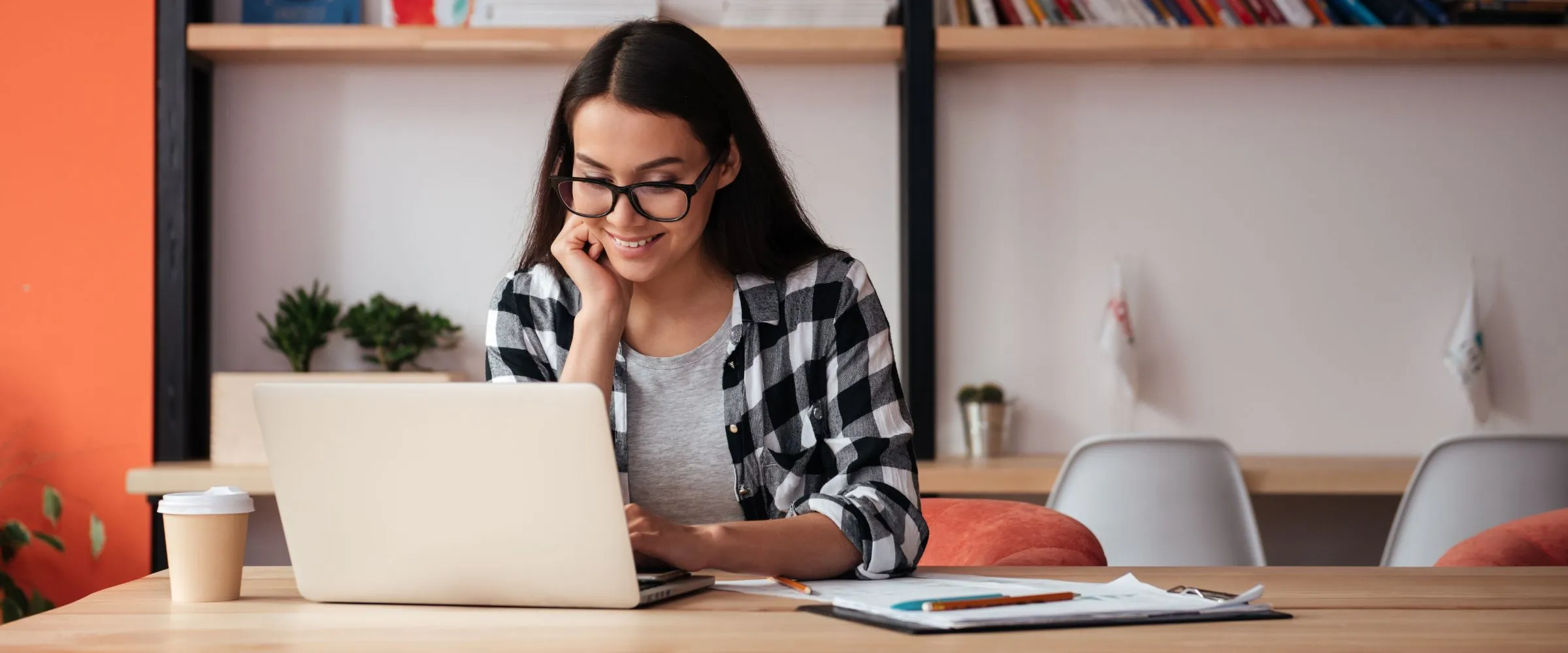 Young woman smiling at laptop.